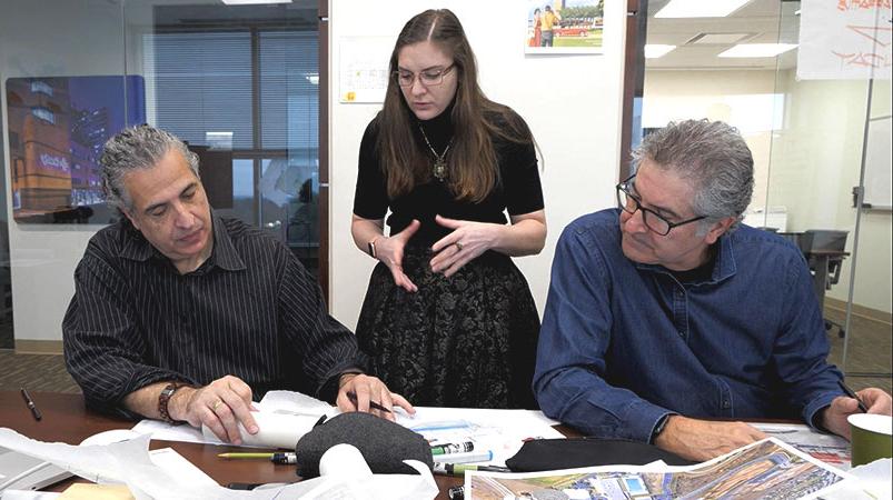 Three individuals collaborate during a design charrette